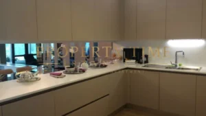 L-shaped kitchen with mirrored backsplash and beige cabinets in a Maslak 1453 apartment