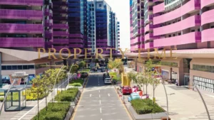 Tree-lined street and shops between glass-fronted residential towers at Maslak 1453