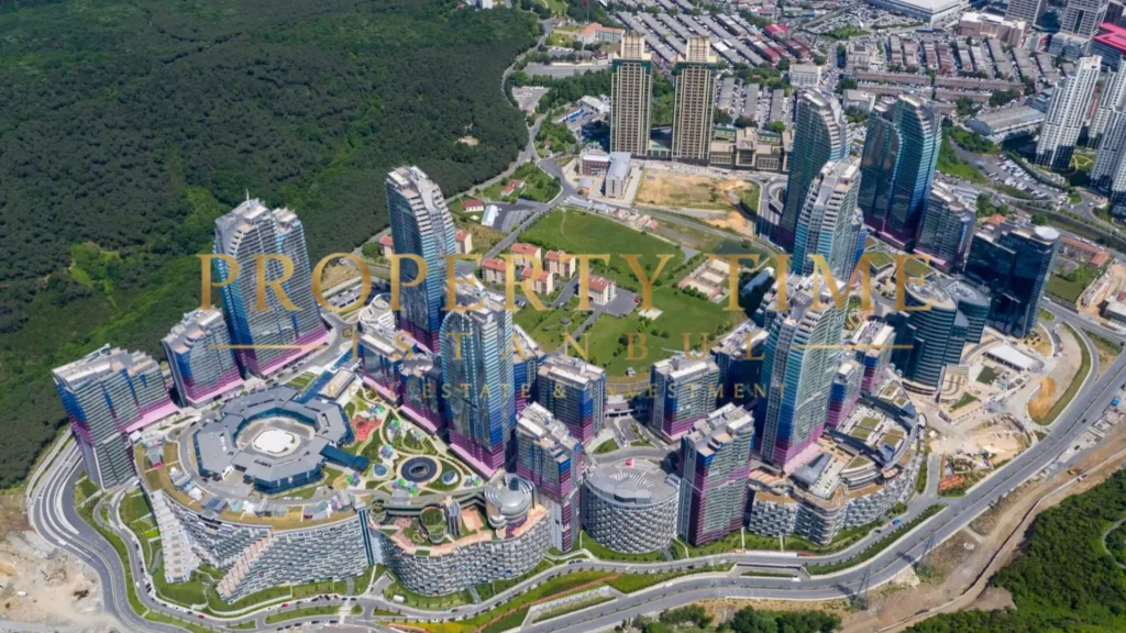 Aerial view of the Maslak 1453 complex at the forest edge: towers, crescent-shaped terraced blocks and mall